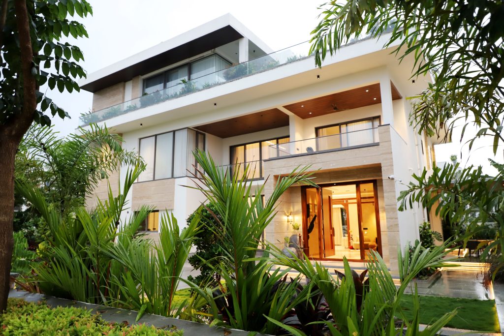 A modern luxury villa surrounded by lush greenery, showcasing contemporary architectural design.